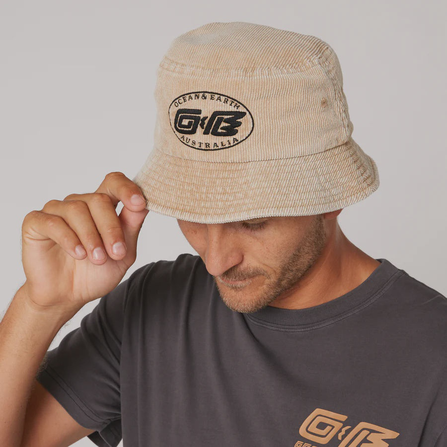 Ocean & Earth Heritage Bucket Hat in almond color, showcasing a stylish, wide-brim bucket hat with brand logo detail.